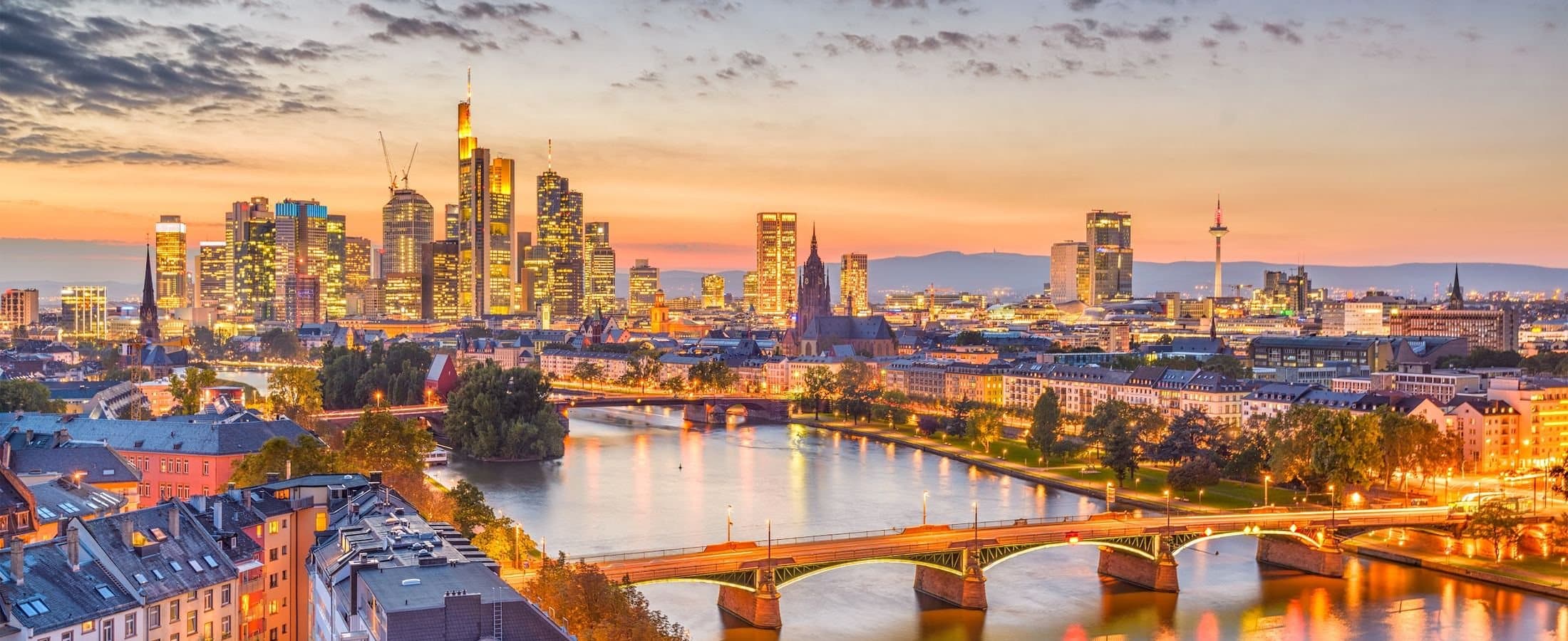 The Frankfurt skyline at dawn, with the river Main in the foreground