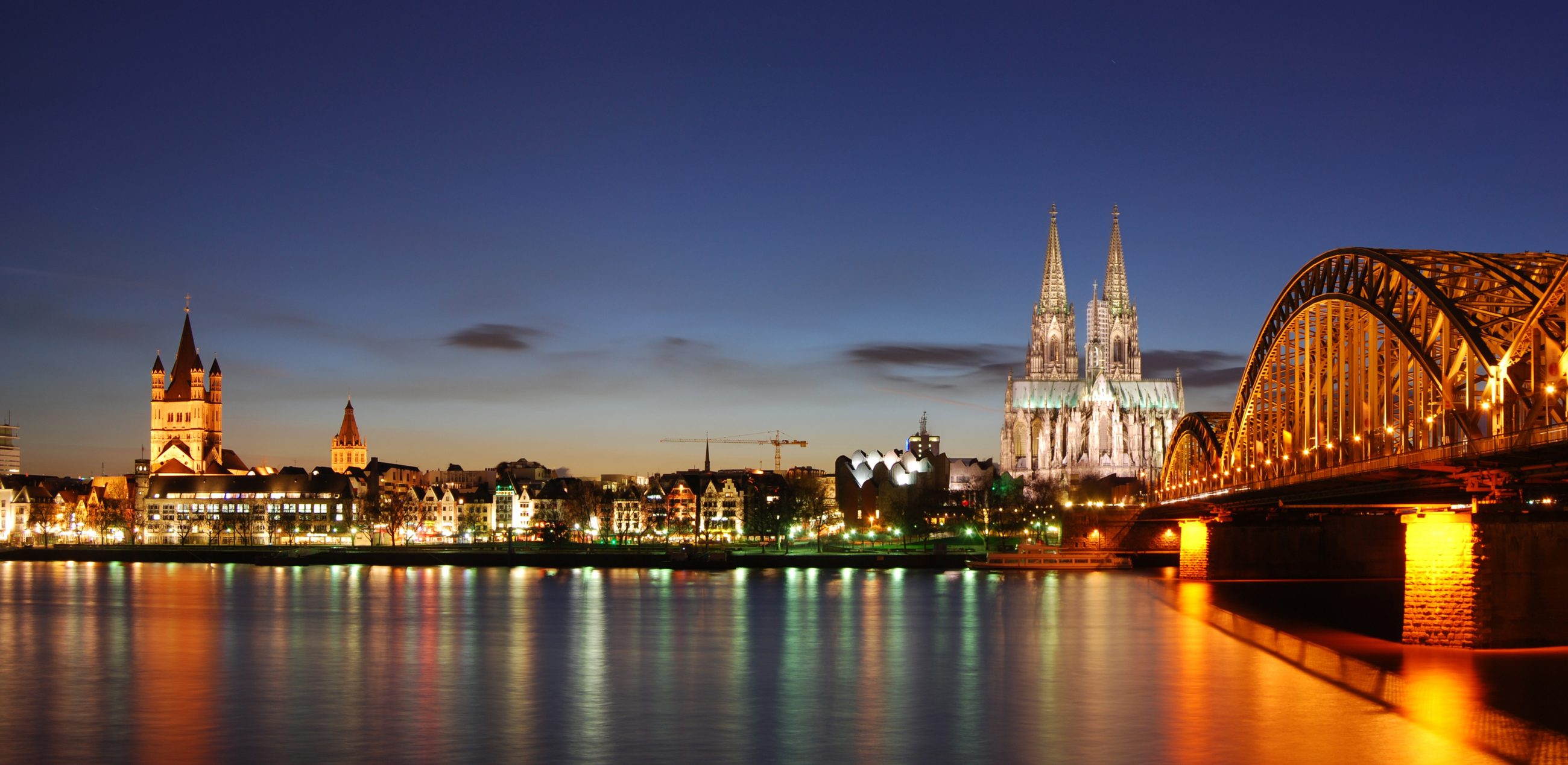 Cologne on the Rhine at dusk, with the cathedral, Great St. Martin and the Hohenzollern bridge